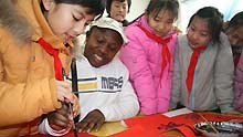 Foreign teacher Del learns to write the spring couplets under a student's guide at Boxing County, east China's Shandong Province, on January 11, 2009, to welcome the forthcoming Chinese traditional Spring Festival which falls on January 26 this year.