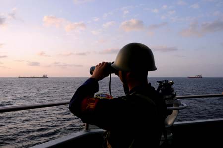 A Chinese marine looks through a telescope aboard missile destroyer Wuhan in the waters of the Gulf of Aden on January 12, 2009. 