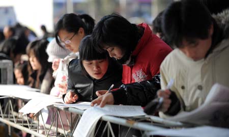 College graduates attend a job fair in Hangzhou, capital of east China's Zhejiang Province on January 13, 2009. Some 700 companies provided 12,000 positions during the job fair on Tuesday.