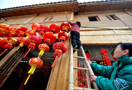 Two women decorate their shop with lanterns in Fuzhou, capital of east China's Fujian Province on January 13, 2009, as the traditional Chinese Lunar New Year approaches.