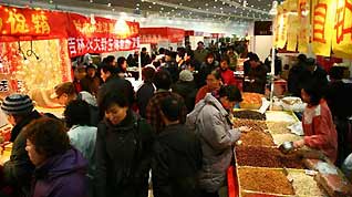 People buy commodities at a trade fair during a culture festival with the theme of greeting the Spring Festival in Xinghai Exhibition Center in Dalian, northeast China's Liaoning Province, on January 13, 2009. As the Spring Festival draws near, people start to buy goods for celebration and family reunion. The Spring Festival, or the Chinese lunar New Year, falls on on January 26 this year.