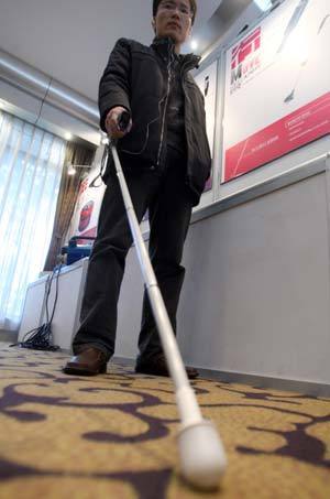 A man tries an intellective seeing eye cane, which can remind the blind through ultrasonic when testing the obstacles, in Hangzhou, capital of east China's Zhejiang Province, on January 12, 2009. A program to improve information accessibility for China's disabled population was launched here by China Disabled Persons' Federation and the Ministry of Science and Technology on Monday.