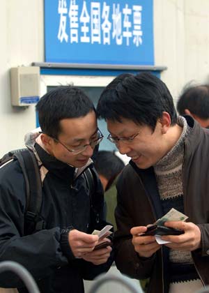 Two men chat after buying tickets at the Beijing West Railway Station in Beijing, capital of China, on January 13, 2009, as the traditional Chinese Lunar New Year approaches.