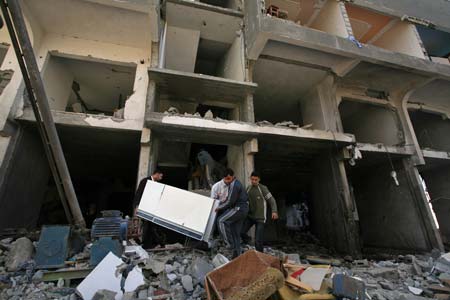 Palestinians fetch living articles from their houses destroyed by Israeli strikes in the al Karama area of Gaza City on Jan. 13, 2009. Israeli soldiers fought heavy battles with local militants in Gaza early Tuesday. Medics said Monday that over 900 people have been killed and more than 4,100 others wounded since Israeli military operation on December 27, 2008.