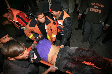 Palestinian medics send a wounded man of the Civil Defense, who was hurt in an Israeli strike, to Shifa hospital in Gaza City, January 14, 2009. Gaza emergency chief Mo'aweya Hassanein said on Wednesday night that the Israeli army killed on Wednesday 28 Palestinians and wounded 80 others. [Xinhua]