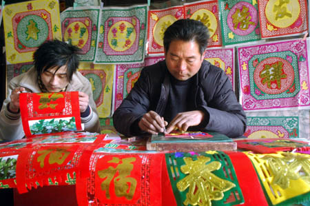 Villagers make traditional decoration for doors presenting good wishes in Tancheng County, east China's Shandong Province, on January 13, 2009, to welcome the forthcoming Chinese traditional Spring Festival, which falls on January 26 this year.