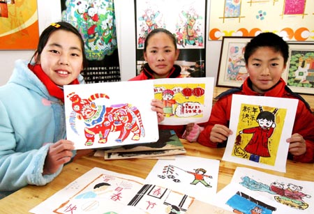 Pupils shows their handmade Taohuawu woodcut New Year paintings in Taowu Central Elementary School in Suzhou, east China's Jiangsu Province, on January 14, 2009.