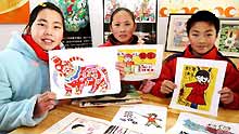 Pupils shows their handmade Taohuawu woodcut New Year paintings in Taowu Central Elementary School in Suzhou, east China's Jiangsu Province, on January 14, 2009.