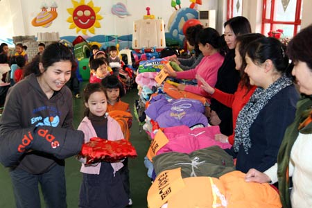 Kids and their teacher in kindergarten donate clothes during a charity activity held at Beijing No.1 Kindergarten in Beijing, on January 15, 2009. Kids and teachers from 7 kindergartens in Beijing on Wednesday donated more than 2600 winter clothes to the 2 kindergartens in the earthquake-hit areas in southwest China's Sichuan Province.