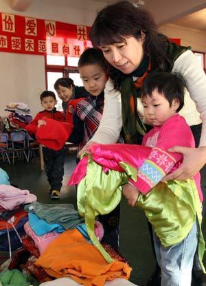 Kids and their teacher in kindergarten donate clothes during a charity activity held at Beijing No.1 Kindergarten in Beijing, on January 15, 2009. Kids and teachers from 7 kindergartens in Beijing on Wednesday donated more than 2600 winter clothes to the 2 kindergartens in the earthquake-hit areas in southwest China's Sichuan Province.