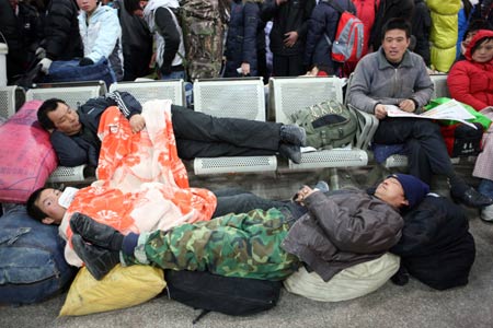 Migrant workers rest as they wait for their train back home at the Beijing West Railway Station in Beijing on January 15, 2009. China's annual Spring Festival pessenger rush is getting started these days as the Spring Festival comes close.