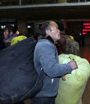 A migrant worker checks the timetable at the Beijing West Railway Station in Beijing on January 15, 2009. China's annual Spring Festival pessenger rush is getting started these days as the Spring Festival comes close.