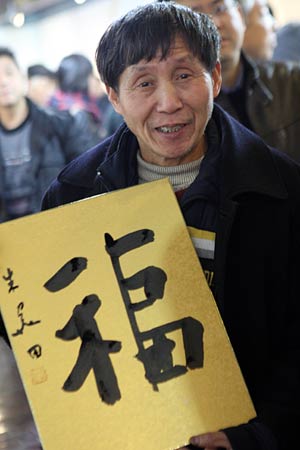 Wang Wanlin, who has helped more than 300 waifs, shows a calligraphy work of 'fu', meaning 'good wishes', during a calligraphy activity held in Hangzhou, capital of east China's Zhejiang Province, on January 15, 2009, to greet the Chinese lunar New Year starting from January 26.