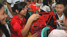 Philippine students receive a Chinese knot as a gift from their Chinese companions at the Raja Suliman Science And Technology High School in Manila, the Philippines, on January 15, 2009. Invited by Philippine President Gloria Macapagal-Arroyo, a group of 100 children who survived a devastating earthquake in China last May arrived in the Philippines on Sunday for a week-long trip.