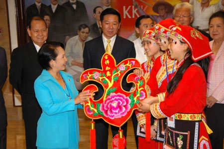 Philippine President Gloria Macapagal-Arroyo (L Front) receives a traditional Chinese decoration from students from China's quake-hit Sichuan Province at the Presidential Palace Malacanang in Manila, capital of the Philippines, on January 16, 2009. Invited by Philippine President Gloria Macapagal-Arroyo, a group of 100 children who survived a devastating earthquake in China last May arrived in the Philippines on Sunday for a weeklong trip. [Xinhua]