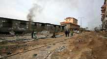 Palestinian people walk past a destroyed area after Israeli military operations in the Tal al Hawa area of Gaza City, on January 16, 2009. The death toll in Gaza has risen to more than 1140 since the beginning of the Israeli massive attack on Gaza on December 27, 2008, with about 5150 wounded, Gaza emergency chief Mo'aweya Hassanein said on Friday. [Xinhua]