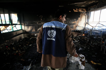 A Palestinian UN worker inspects debris at an UN-run school at Beit Lahya in northern Gaza Strip on January 17, 2009. At least four Palestinians were killed during an Israeli strike on the UN-run school on Saturday morning, where civilians were sheltering from fighting, local medical sources and witnesses said.