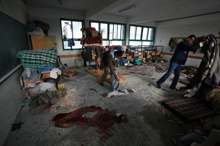 Palestinian UN worker inspects debris at an UN-run school at Beit Lahya in northern Gaza Strip on January 17, 2009.