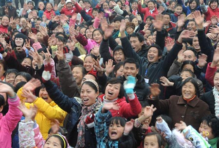 Villagers celebrate for moving to permanent dwellings in front of their new residences at Anren Village of Mianzhu City, southwest China's Sichuan Province, January 18, 2009. A total of 332 Anren villagers whose houses collapsed or dilapidated during the May 12 massive earthquake last year feasted on Sunday to celebrate the resettlement. [Xinhua]