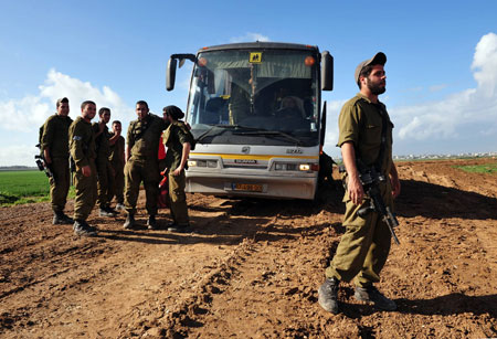 Israeli soldiers wait to go back by bus at Israel-Gaza border after returning from the Gaza Strip on January 18, 2009.