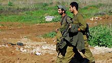 Israeli soldiers walk on Israel-Gaza border after returning from the Gaza Strip on January 18, 2009. The Israeli army has begun withdrawing its troops from the Gaza Strip on Sunday evening, local news service Ynet reported.