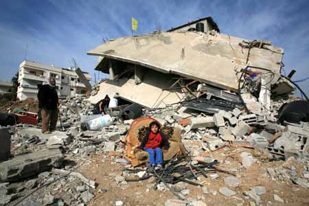 A Palestinian child sits in front of destroyed houses by Israeli strikes in the east of northern Gaza Strip, on January 19, 2009. Right after a ceasefire was declared by both Israel and Gaza militant groups, thousands of Gaza residents went back to their homes they had fled during the war, only to see how huge the destruction was.