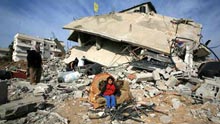 A Palestinian child sits in front of destroyed houses by Israeli strikes in the east of northern Gaza Strip, on January 19, 2009. Right after a ceasefire was declared by both Israel and Gaza militant groups, thousands of Gaza residents went back to their homes they had fled during the war, only to see how huge the destruction was.