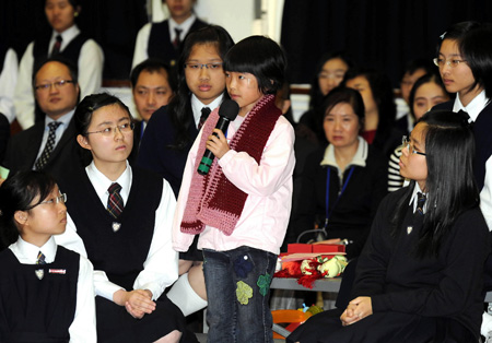 Xia Fengting (C), a little girl from the quake-hit area in southwest China's Sichuan Province, narrates her experiences in the earthquake in Hong Kong, south China, on January 19, 2009.