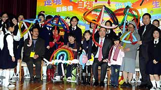 Representatives from the quake-hit area in southwest China's Sichuan Province pose for a group photo with students and teachers at a school in Hong Kong, south China, on January 19, 2009.