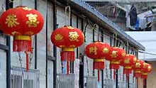 A woman walks out of a temporary dwelling decorated with red lanterns in Chenjiaba Township of Beichuan County, southwest China's Sichuan Province, on January 20, 2009, before the Chinese lunar New Year starts from January 26. Beichuan was one of the areas hit most seriously by the May 12 earthquake last year.