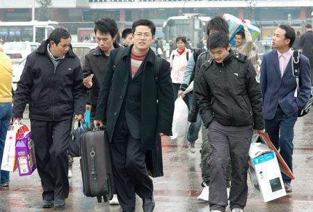 Passengers walk on the square in front of the Changsha Railway Station in Changsha, capital of central-south China's Hunan Province, on January 21, 2009. 