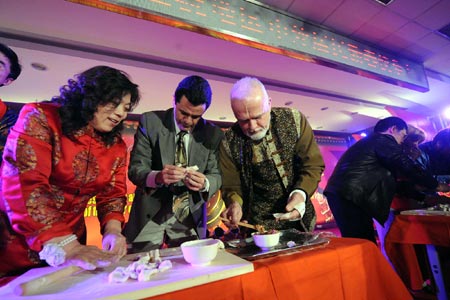 Chinese and foreign residents make Jiaozi during a celebration for the Chinese lunar New Year in a community in the Chaoyang District of Beijing, capital of China, on January 20, 2009.