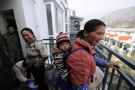 Villagers are seen in their new houses at Qipan village in Xiang'e town of Dujiangyan City, southwest China's Sichuan Province, on January 21, 2009. As their homestead was destroyed in the earthquake in May 2008, 80 percent of 274 families in Qipan village have moved to new houses recently.