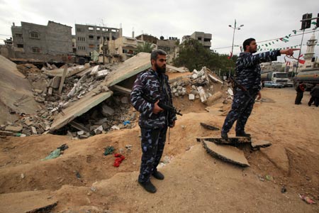 Hamas policemen are seen at the ruins of al-Zaitoun police station, destroyed in Israeli military strikes, in southeast Gaza City, on January 20, 2009.The Israeli military attacks on the Gaza Strip have left 1,414 Palestinians dead and 5,500 others wounded.