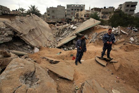 Hamas policemen are seen at the ruins of al-Zaitoun police station, destroyed in Israeli military strikes, in southeast Gaza City, on January 20, 2009.