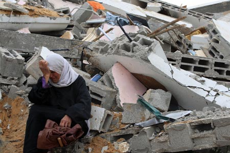 An old Palestinian woman sits in the rubble of her house destroyed in Israeli military strikes in al-Zaitoun neighborhood in southeast Gaza City, on January 20, 2009.