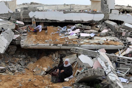 An old Palestinian woman sits in the rubble of her house destroyed in Israeli military strikes in al-Zaitoun neighborhood in southeast Gaza City, on January 20, 2009.