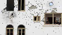 Palestinians look out of the balcony of the house damaged in Israeli military strikes in the al-Zaitoun neighborhood in southeast Gaza City, on January 20, 2009.