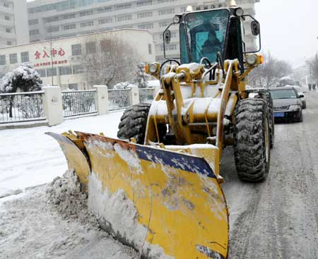 A bulldozer cleans snow in Shenyang, capital of northeast China's Liaoning Province, on January 22, 2009. An overnight snow hit Shenyang for the first time in 2009.