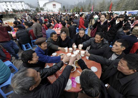 Villagers toast during a banquet to celebrate moving into new house in Dongjiaxinyuanzi town of Dujiangyan City, southwest China's Sichuan Province, on January 22, 2009. As their homestead was destroyed in the earthquake in May 2008, about 400 families in Dongjiaxinyuanzi town moved to new houses on January 22. 