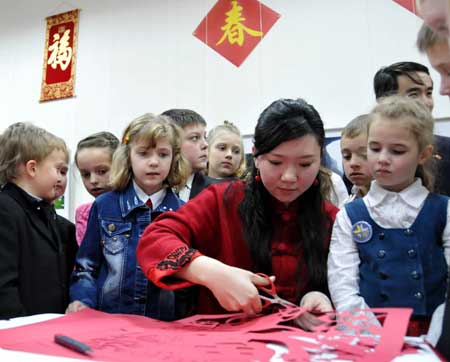 Meng Li, a Chinese overseas student, shows the skill of paper-cut to the students of Belarus in Minsk on January 22, 2009. Members of the Chinese Embassy in Minsk celebrate Chinese lunar New Year with hundreds of teachers and students of Belarus.