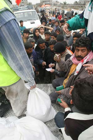 Palestinians receive foods donated by international communities in southern Gaza Strip of Zitton, on January 23, 2009. This area was badly destroyed in the Israeli military operations with many buildings damaged and people left homeless.