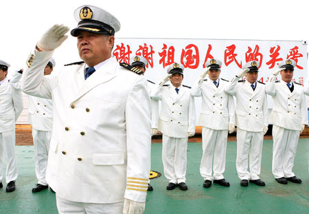 Captain Peng Weiyuan (front) and other crew members of the Chinese cargo ship Zhenhua 4 salute to the crowd in a commendation ceremony at Changxing Island Port in Shanghai, east China, on January 23, 2009.