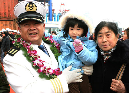 Peng Weiyuan, captain of the Chinese cargo ship Zhenhua 4 pose with his family members during a commendation ceremony at Changxing Island Port in Shanghai, east China, on January 23, 2009.