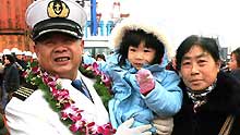 Peng Weiyuan, captain of the Chinese cargo ship Zhenhua 4 pose with his family members during a commendation ceremony at Changxing Island Port in Shanghai, east China, on January 23, 2009.