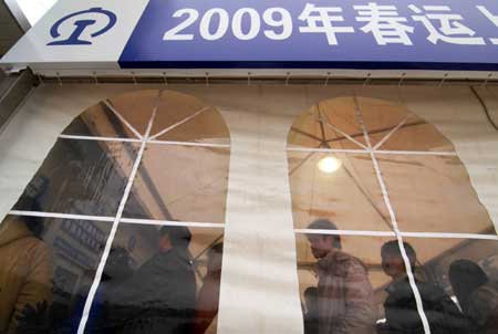 People buy tickets in a temporarily wind- sheltering ticket house in Shanghai, east China, on January 23, 2009. The cold wave is moving south across much of China, causing inconvenience for people struggling to get home for Chinese Lunar New Year. 