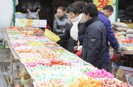 Residents select candies for the imminent Spring Festival at Hanzhong, a quake-hit city of northwest China's Shaanxi Province, Jan. 23, 2009.