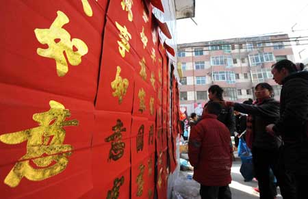 Locals select antithetical couplet for the imminent Spring Festival at Liangshui County of Longnan City, a quake-hit city of northwest China's Gansu Province, Jan. 23, 2009. 