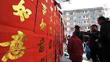 Locals select antithetical couplet for the imminent Spring Festival at Liangshui County of Longnan City, a quake-hit city of northwest China's Gansu Province, on January 23, 2009.