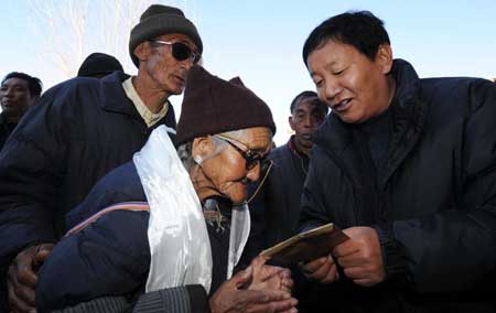 A government official distributes the shopping coupons in Lhasa, capital of southwest China's Tibet Autonomous Region, on January 23, 2009. With the Spring Festival drawing near, the government of Tibet handed out shopping coupons each worth 800 yuan to 37,026 needy citizens receiving the minimum living allowances and 31,375 retirees of state-run firms on Friday.